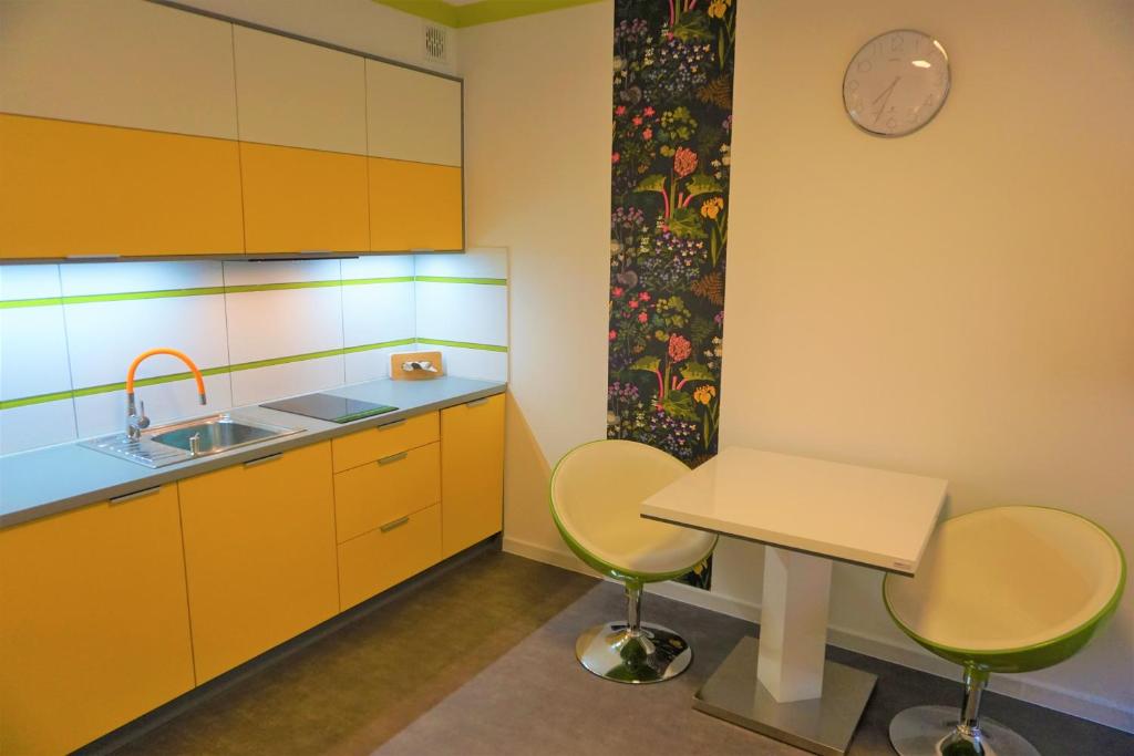 cocina con armarios amarillos, mesa y sillas en Usedom-Apartment im Haus Feniks, en Świnoujście