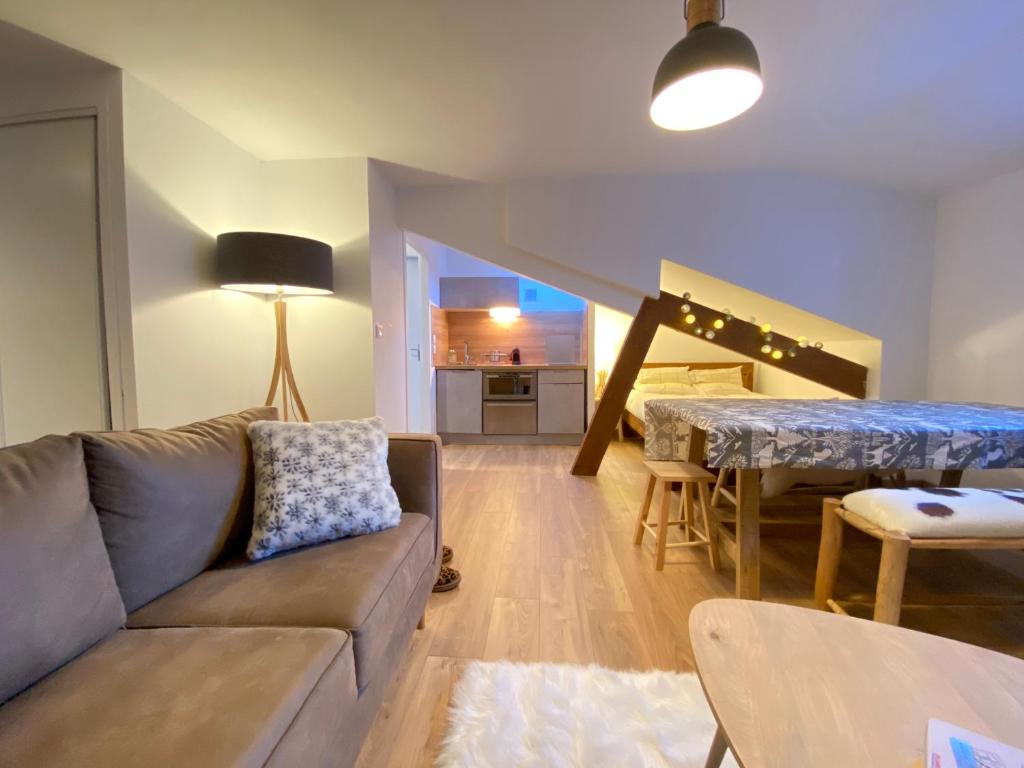 a living room with a couch and a table at Joli studio rénové au coeur de Cauterets in Cauterets