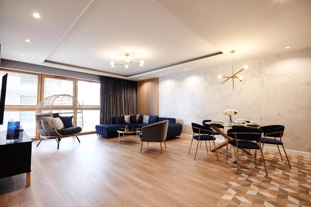 a living room with a couch and a table and chairs at Apartament Navy Residence in Ełk