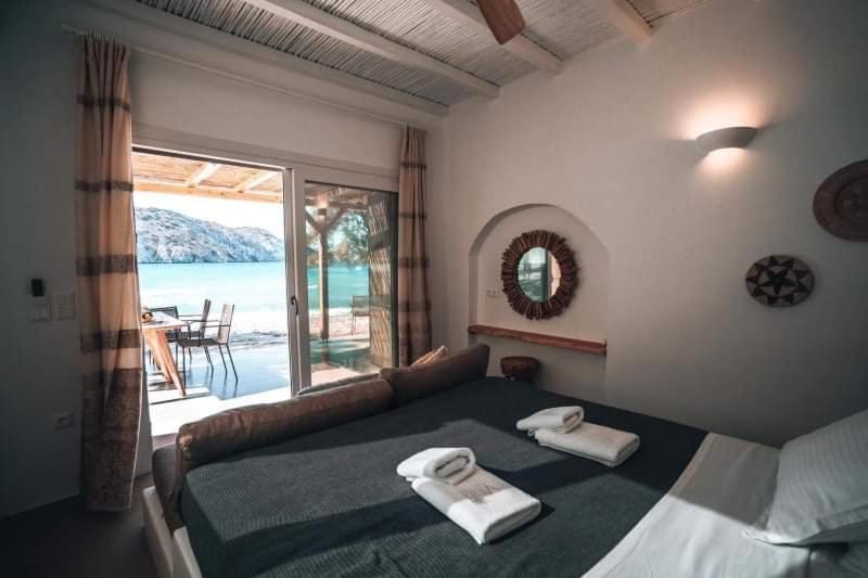 een slaapkamer met een bed met twee handdoeken erop bij Vilos Suites Fyropotamos Beach in Firopótamos