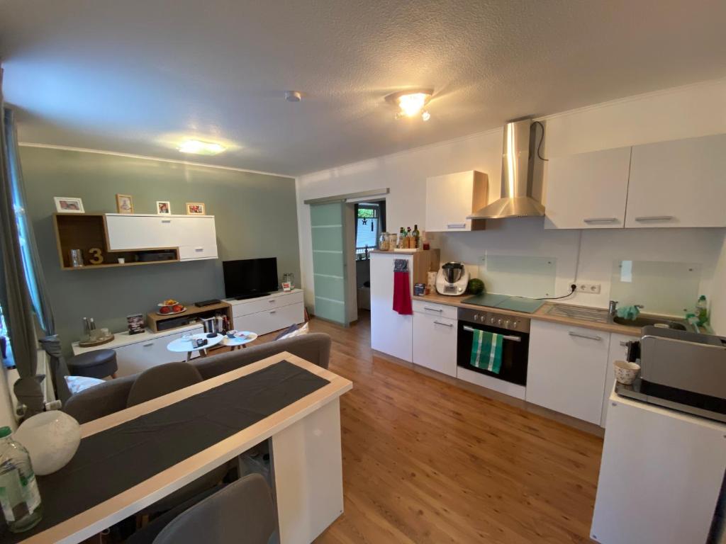 a kitchen and living room with white cabinets at Ferienwohnung Monteurwohnung Gevelsberg in Gevelsberg