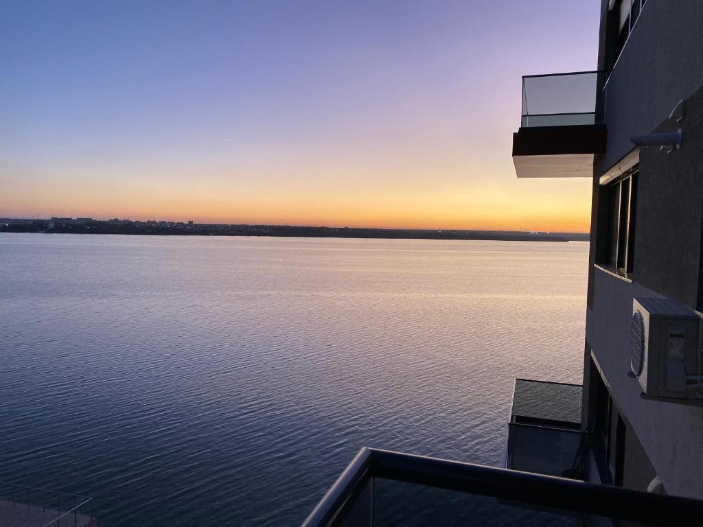 瑪美亞的住宿－C&A Residence Mamaia，从大楼欣赏日落的水景
