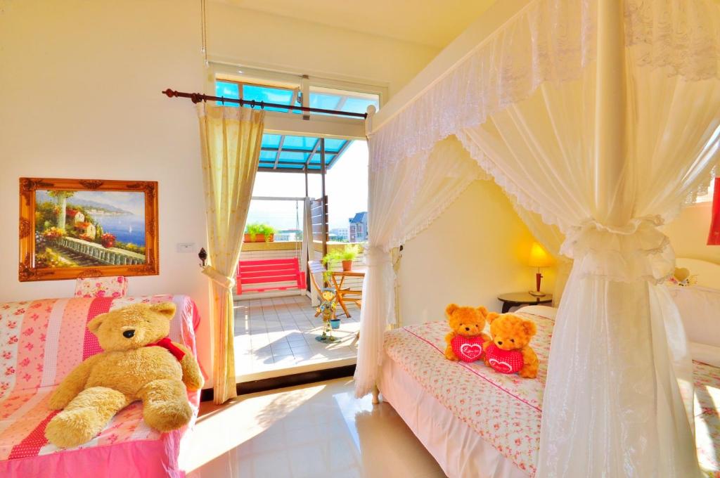 two teddy bears sitting on beds in a bedroom at Happy Orange Homestay in Dongshan