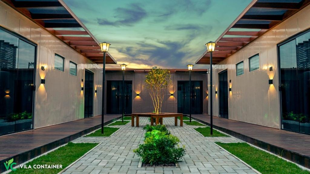 a courtyard of a building with a bench and lights at Vila Container in Penha