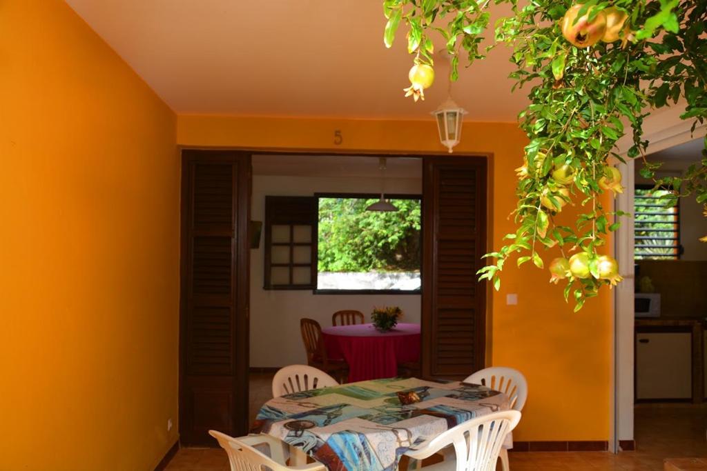 a dining room with a table and chairs at RESIDENCE DE VACANCES MON REFUGE - BUNGALOW DE TYPE T3 in Grande Anse