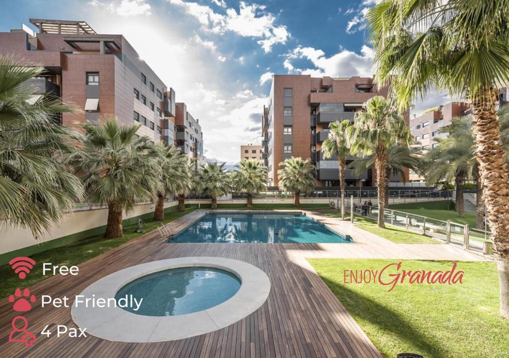 a swimming pool with palm trees and buildings at EnjoyGranada EMIR 3F - POOL, GYM & Free Parking in Granada