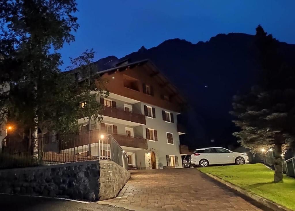 a white car parked in front of a building at night at Baita de Ciano in Valdidentro