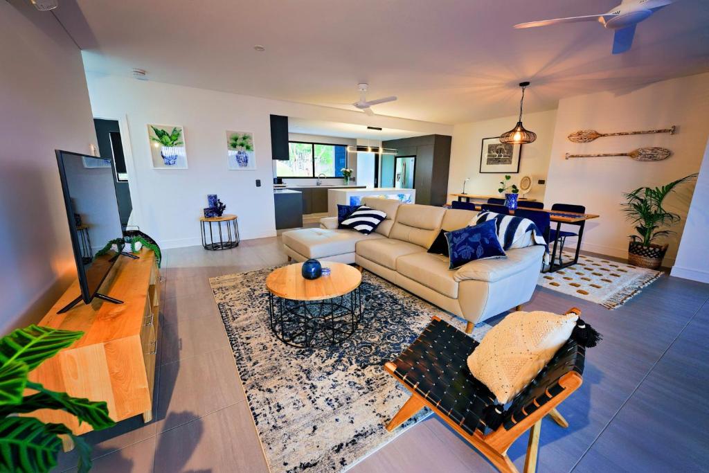 uma sala de estar com um sofá e uma mesa em Valle Vista Luxury Apartments em Cairns