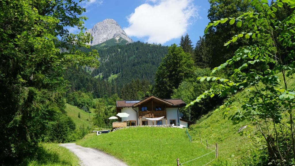 a house on a hill with a mountain in the background at AlpenSportChalet in Werfenweng