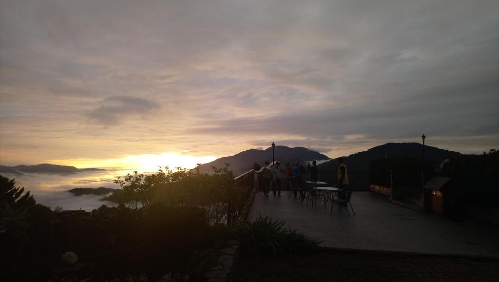 a group of people standing on a patio watching the sunset at Star Villa in Ren&#39;ai