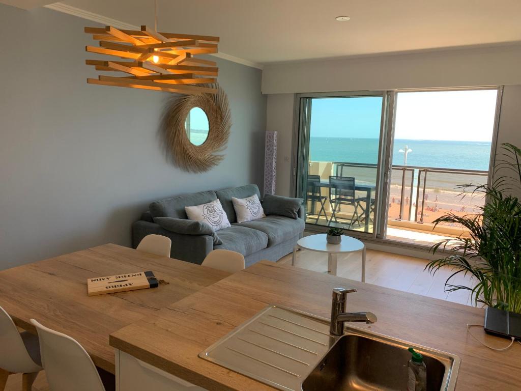 a kitchen and living room with a table and a couch at La Baule Family in La Baule