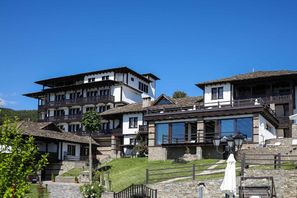 un gran edificio de piedra con un cielo azul en el fondo en Hotel Leshten, en Leshten