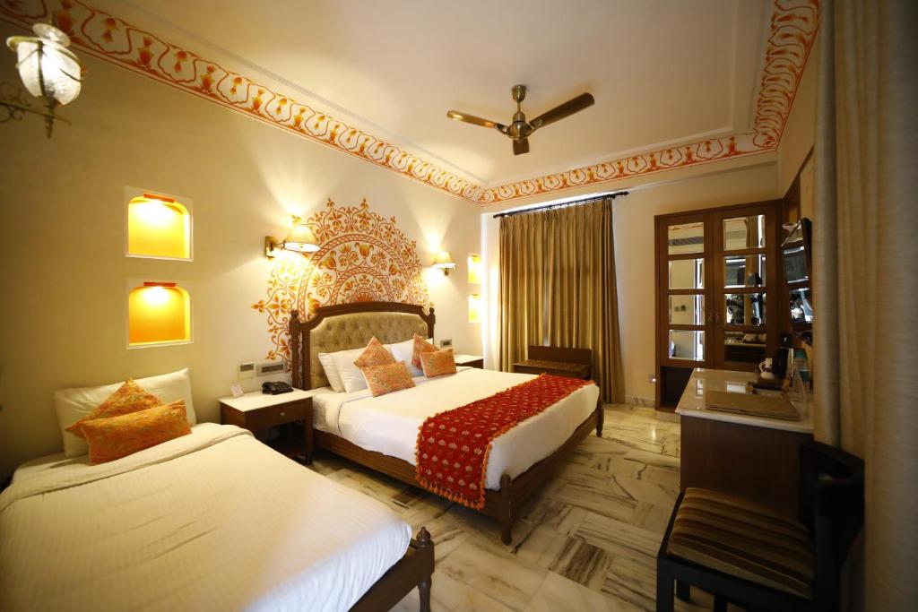 Postel nebo postele na pokoji v ubytování Laxmi Palace Heritage Boutique Hotel