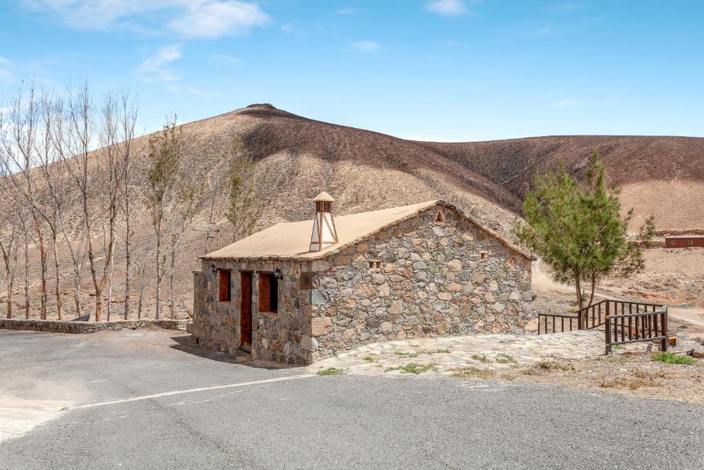 a small stone building in front of a mountain at Casa Alonso in Pájara