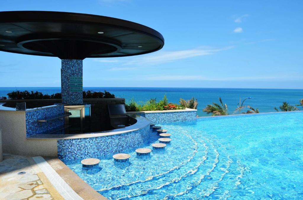 a pool at a resort with the ocean in the background at H Resort in Checheng