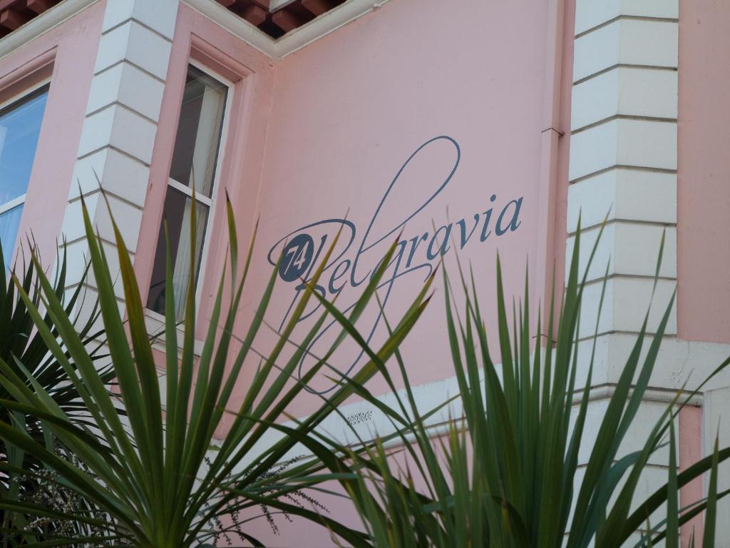 un edificio rosa con un cartel que dice péndulo en 74 Belgravia, en Torquay