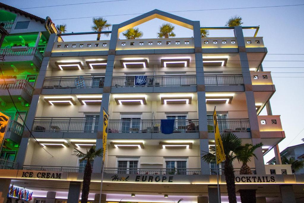 un bâtiment avec des lumières sur son côté dans l'établissement Hotel Europe, à Paralia Katerinis