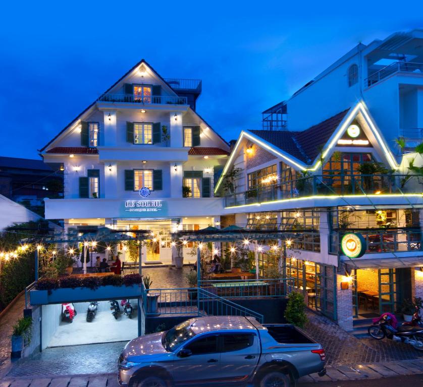 una furgoneta estacionada frente a un edificio por la noche en Le Soleil Boutique Hotel en Da Lat