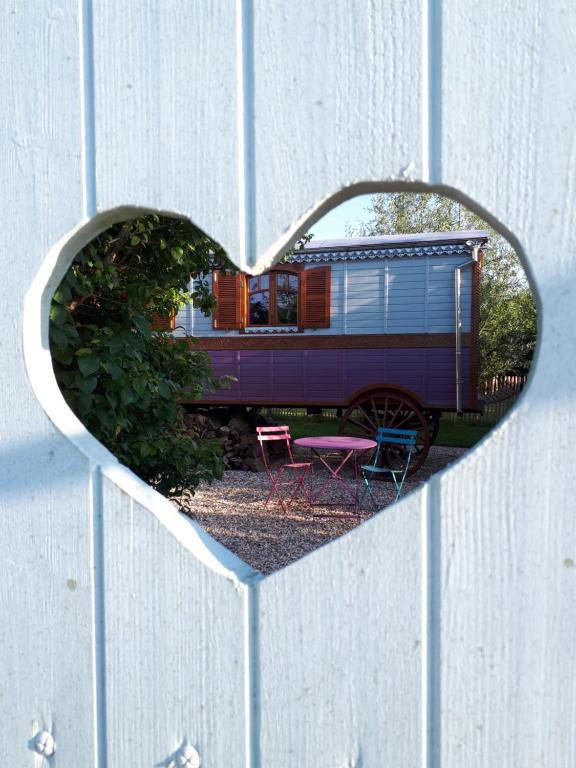 a mirror in the shape of a heart on a fence at La roulotte de Glorit in Bourg-sur-Gironde
