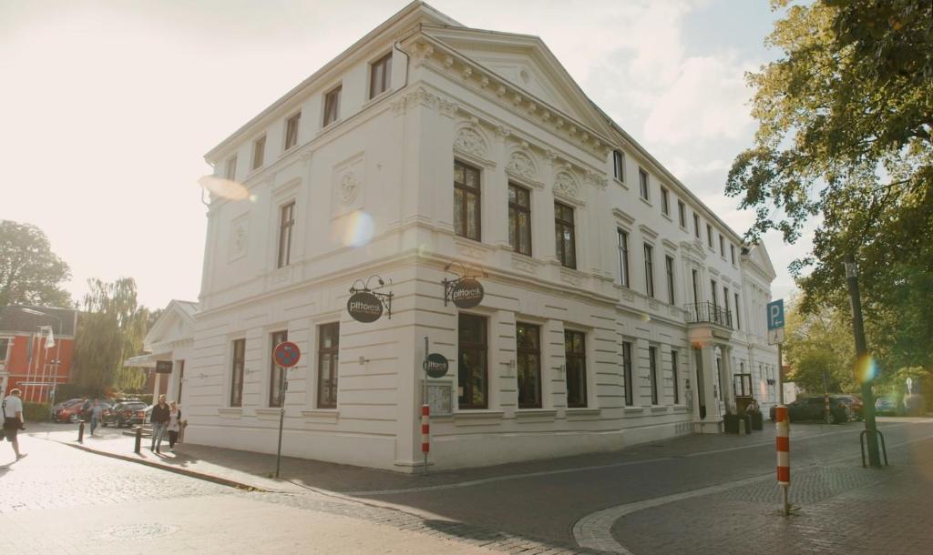 a white building on the corner of a street at Hotel Am Schloss Aurich in Aurich