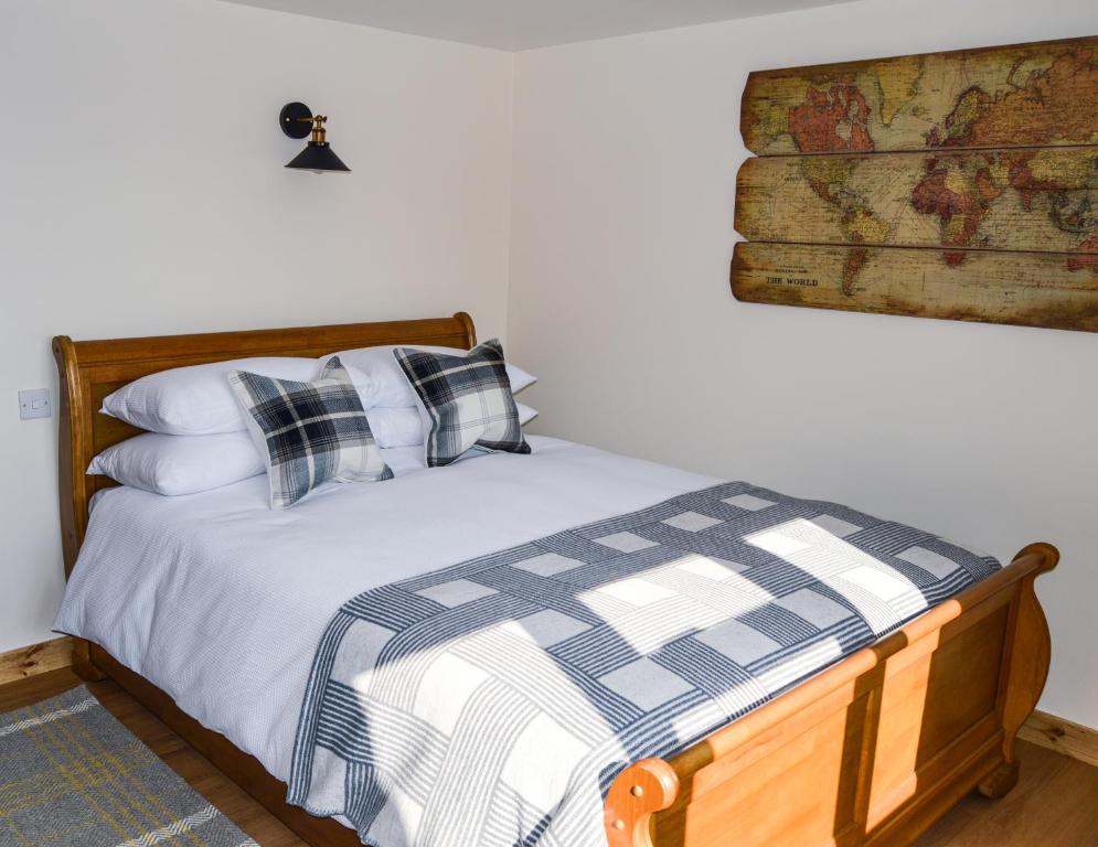 een bed met geruite kussens in een slaapkamer bij Bluebell Cottage at The Old Tractor Barn in Brackley