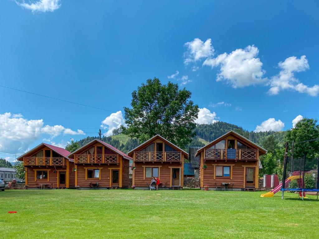 ein Blockhaus mit einem Spielplatz davor in der Unterkunft Eco Centr Zrub in Maydan