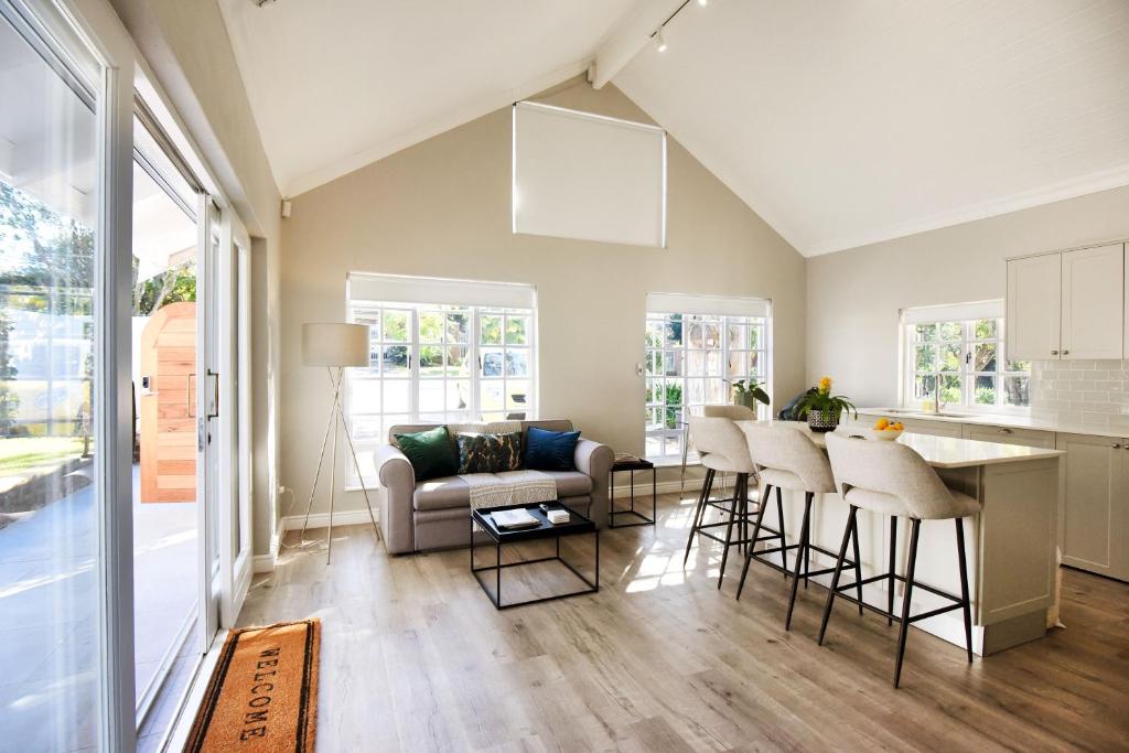 a living room with a couch and a table at The Rose Cottage in Cape Town