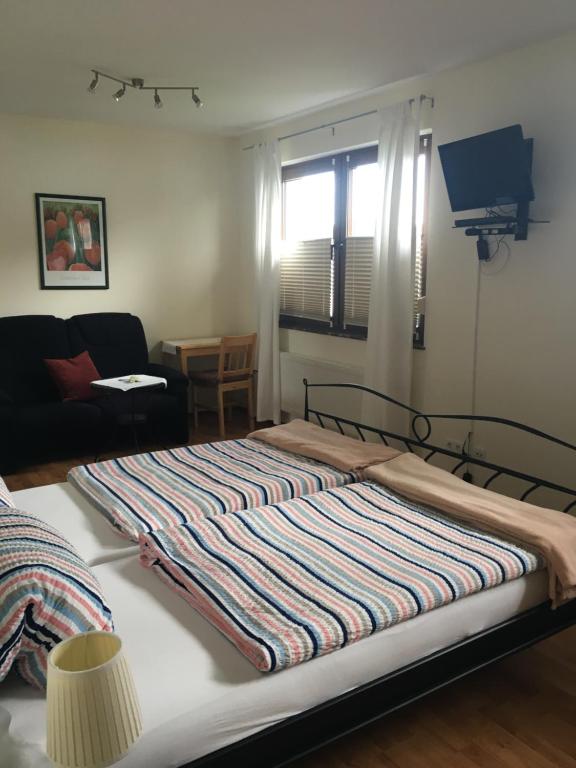 a bed with a striped blanket on it in a room at Gasthof zum Seeweiher in Dreifelden