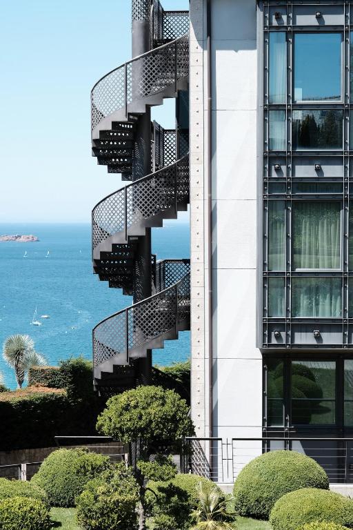 a spiral staircase on the side of a building at L'Agapa Hôtel - Spa Codage in Perros-Guirec