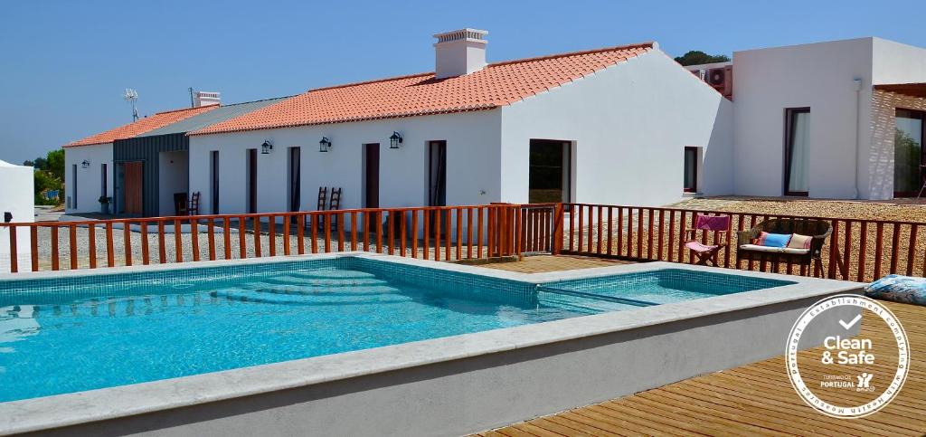 a swimming pool in front of a house at Quinta de São Gabriel in Castro Marim