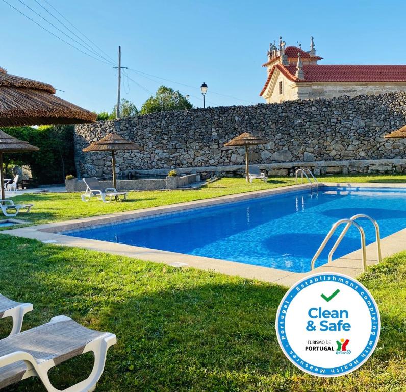 a swimming pool with a tennis court and a blue chair at Hotel Convento Nossa Senhora do Carmo in Freixinho