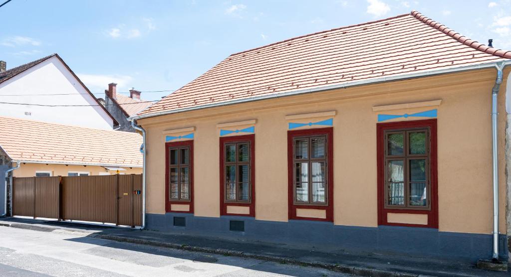 um edifício com janelas vermelhas e uma cerca em Elena Apart em Keszthely
