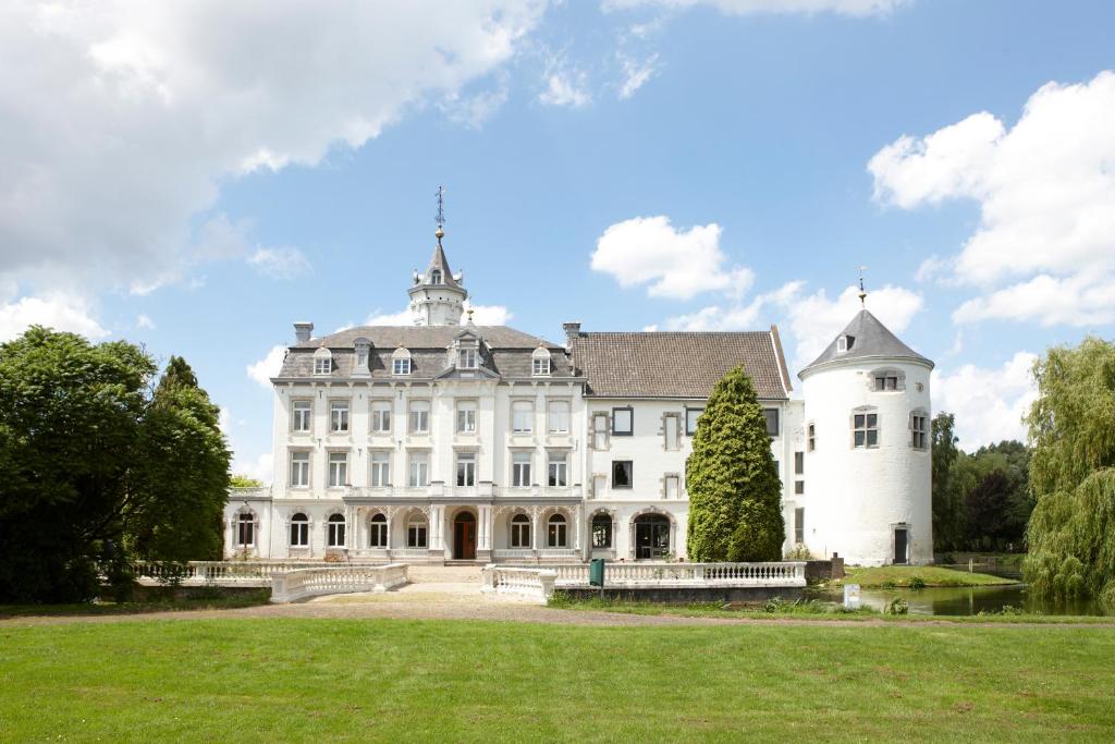 un gran edificio blanco con un árbol en el patio en Teaching Hotel en Maastricht