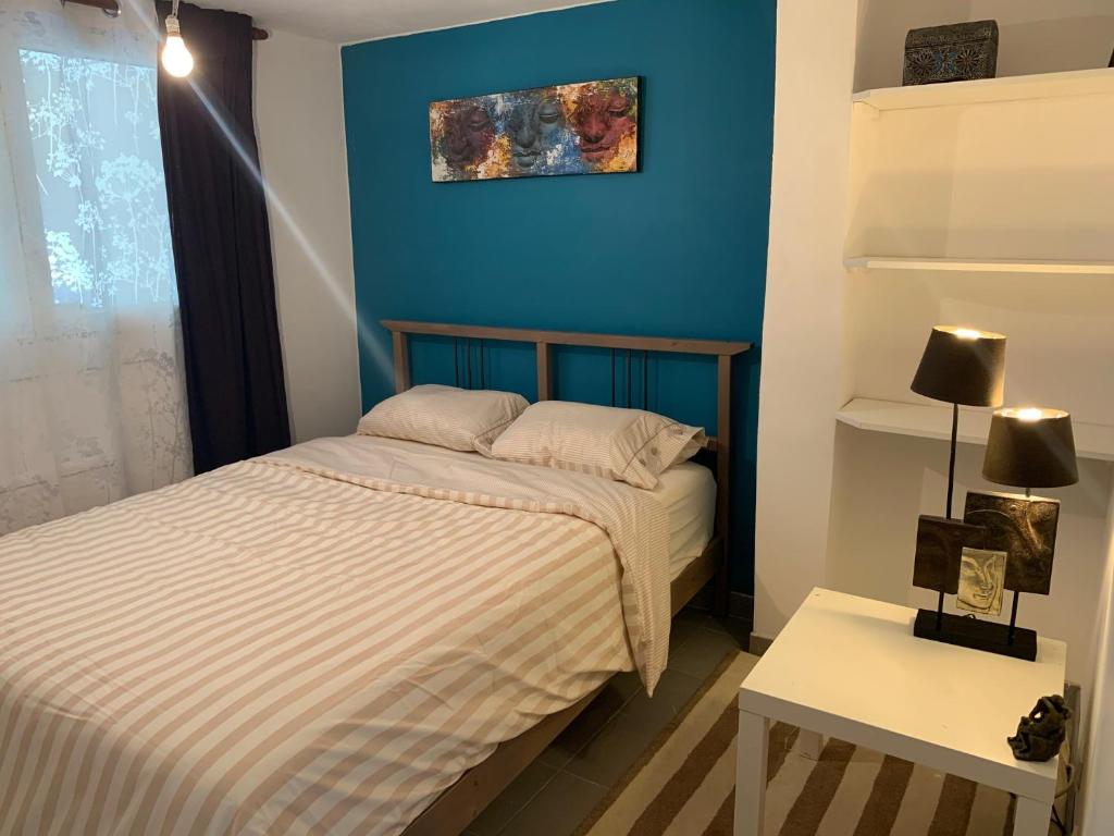 a bedroom with two beds and a blue wall at Logement cosy proche Paris et Disneyland in Villiers-sur-Marne