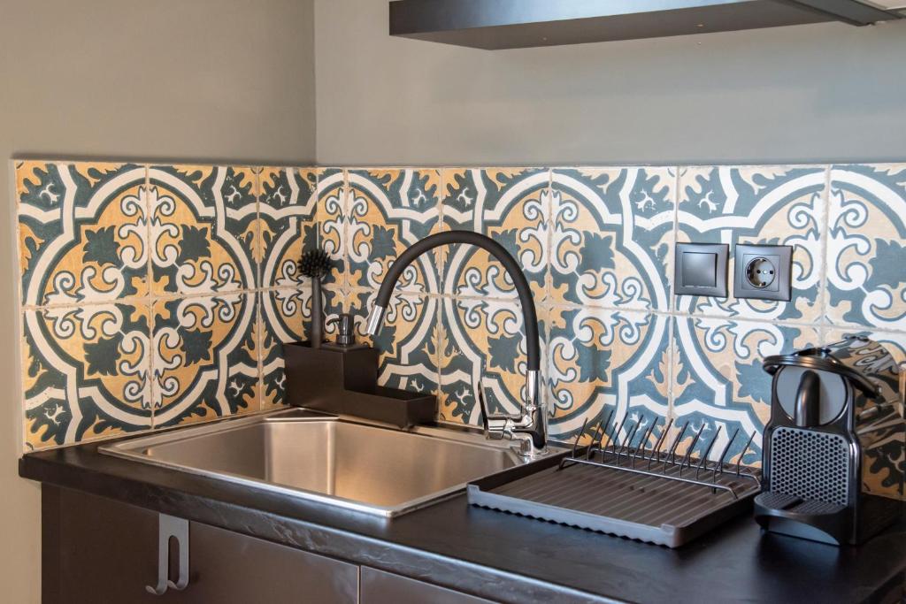 cocina con fregadero de acero inoxidable y pared con estampado en Urban Sea View Lofts #2, en Chalkida