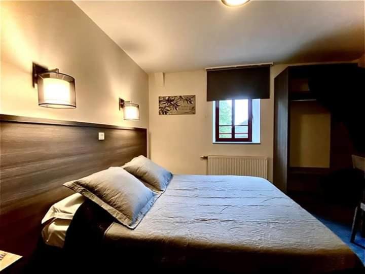 een slaapkamer met een bed met 2 kussens erop bij La Boule d'or in Pouzauges