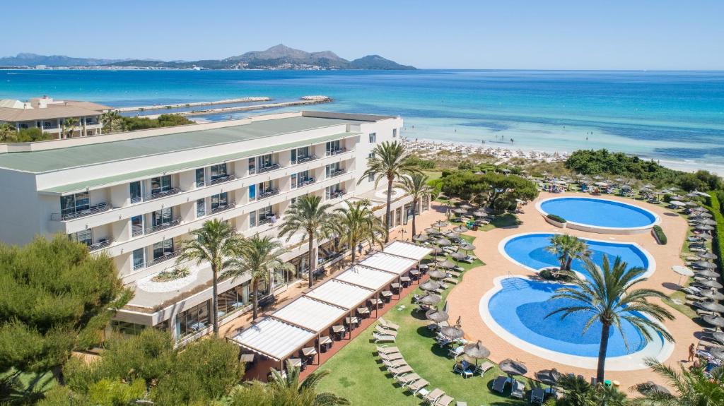 an aerial view of a resort with a pool and beach at Grupotel Natura Playa in Playa de Muro