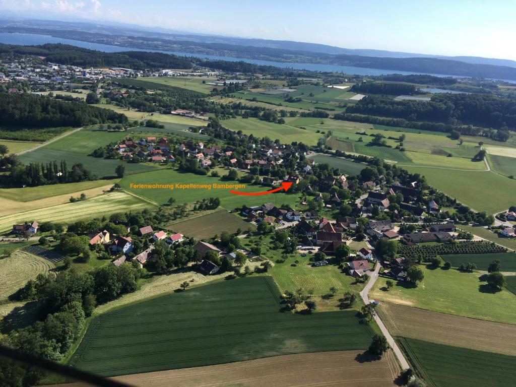 a red kite flying over a green field with houses at Ferienwohnung Kapellenweg Bambergen bei Überlingen in Bambergen