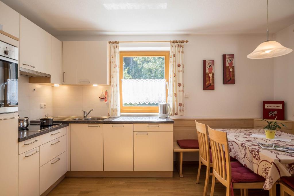 una cucina con tavolo e una sala da pranzo di Apartment Alpenrose - Mesnerhof a Campo Tures