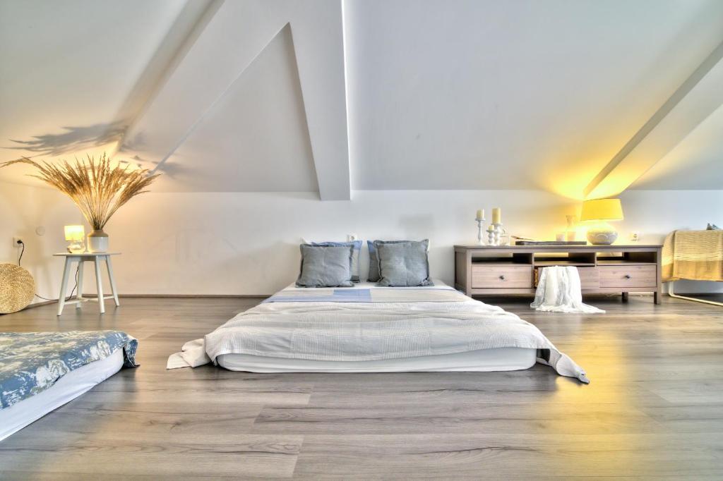 a large white bedroom with a bed and a desk at Dida moj in Senj