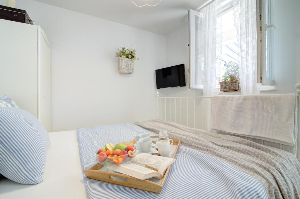a tray of fruit on a bed in a bedroom at Dida moj in Senj