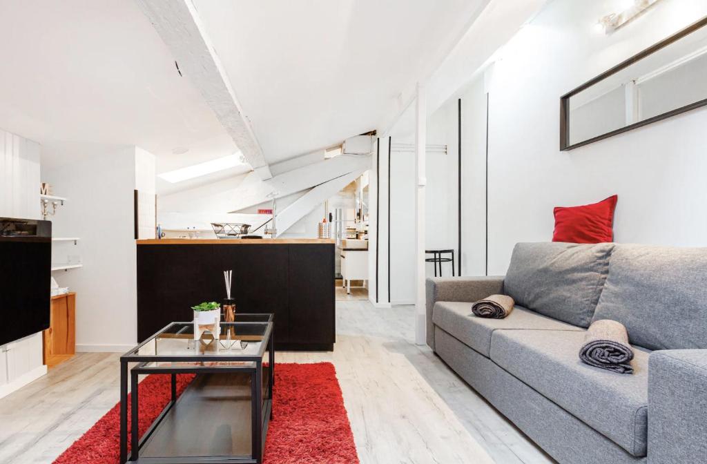 ein Wohnzimmer mit einem Sofa und einem Tisch in der Unterkunft Le Cocon - Chaleureux Studio Centre Ville au Calme in Toulouse