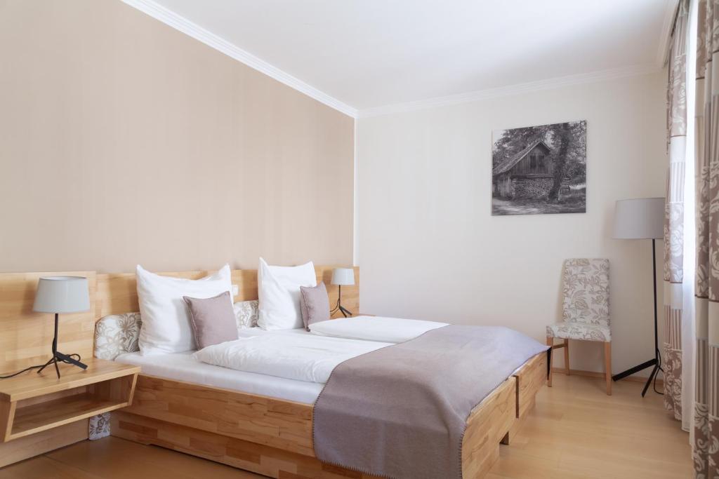 Un pat sau paturi într-o cameră la FrühstücksHotel Scharinger