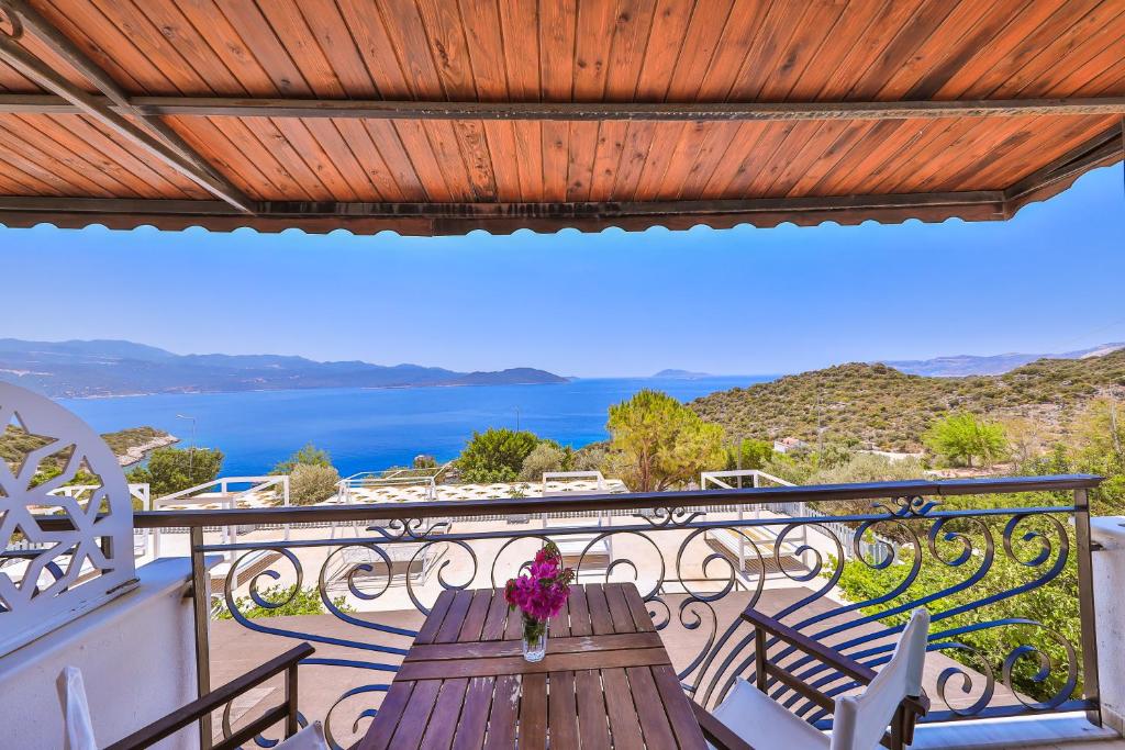 a balcony with a wooden table with flowers on it at Hamarat Otel in Kaş