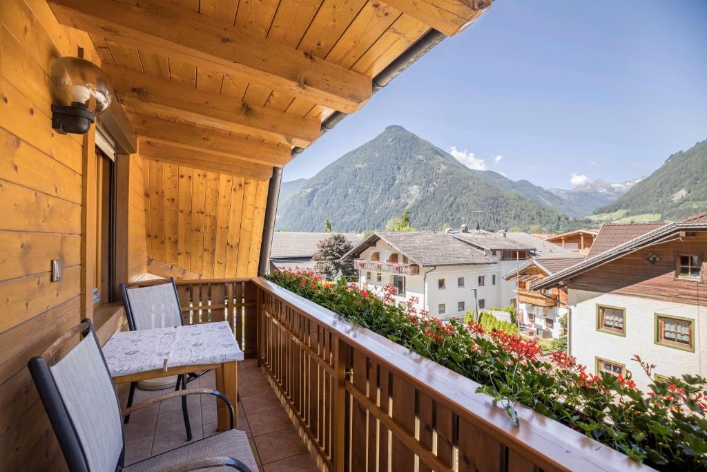 a balcony with chairs and a table and flowers at Apartment Kornblume - Mesnerhof in Sand in Taufers