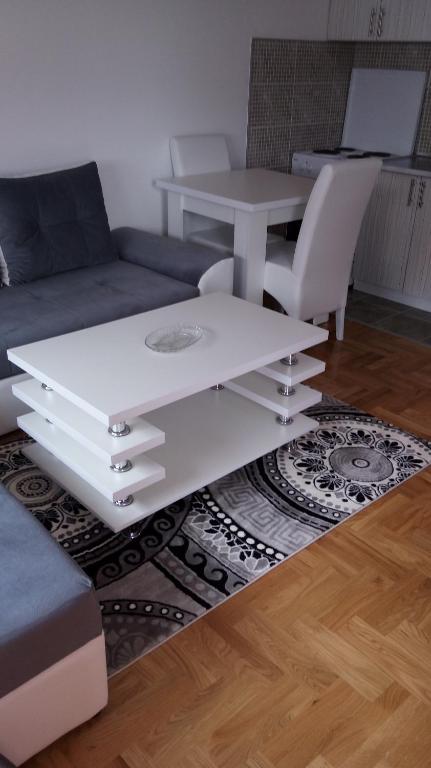 a white coffee table in a living room with a couch at Apartman Sanja in Lukavica