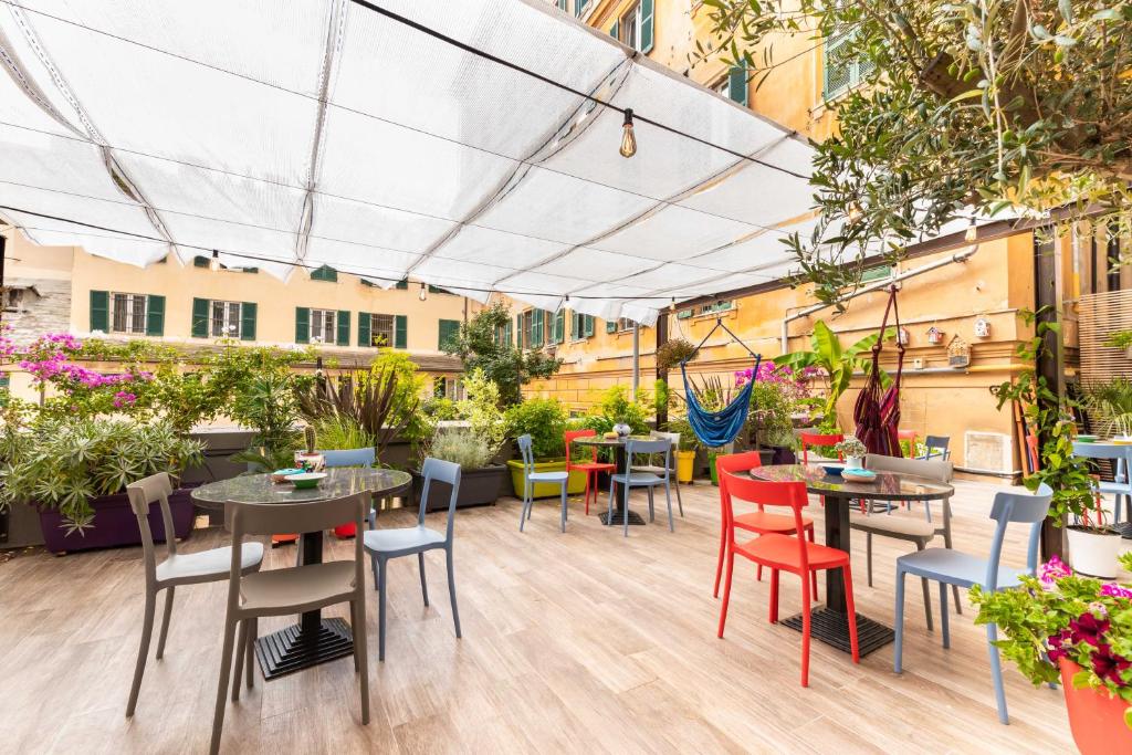 a patio with tables and chairs and plants at Hotel Britannia in Genoa