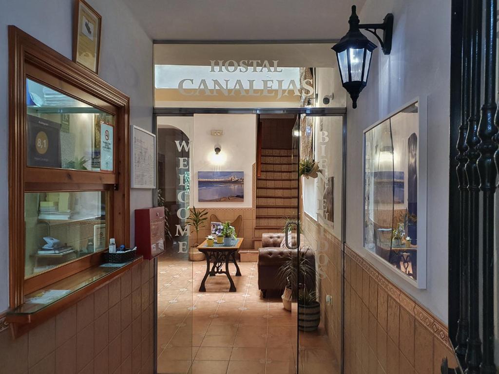 a restaurant with a hallway with a table in a room at Hostal Canalejas in Cádiz