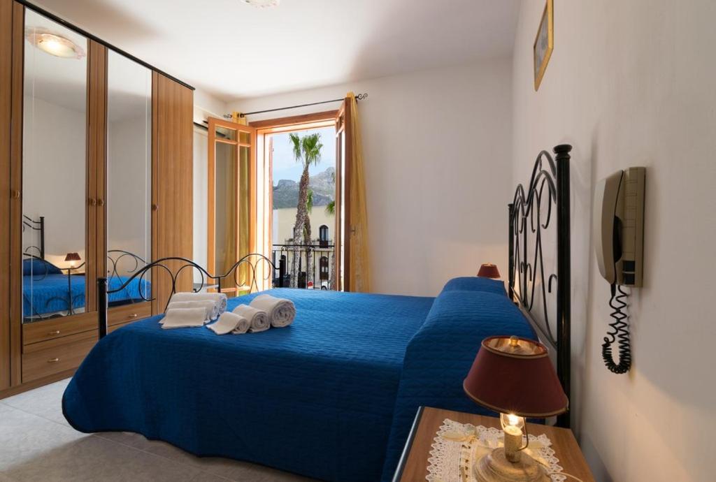una camera da letto con un letto blu e asciugamani di Casa Marinella a San Vito lo Capo