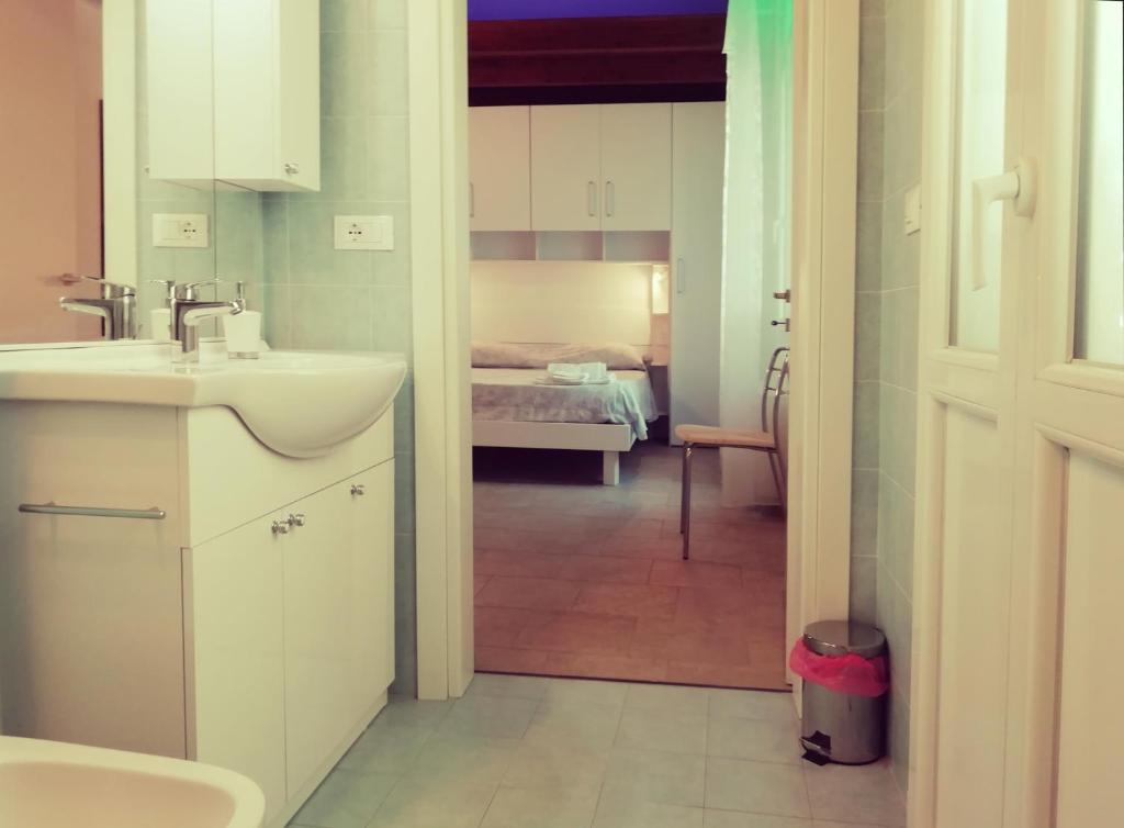a bathroom with a sink and a room with a bed at Le mille e una notte in Comacchio